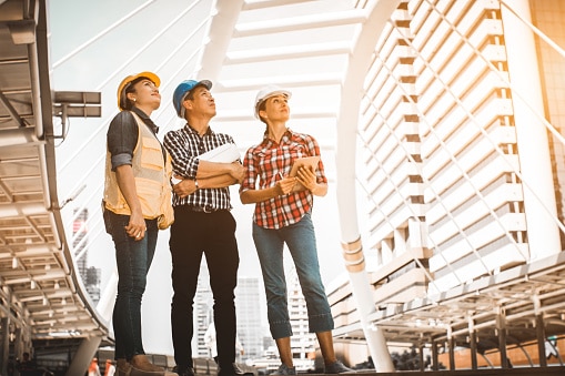 three construction professionals looking up at an industrial project concept